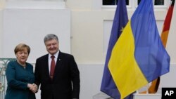 FILE - German Chancellor Angela Merkel, left, welcomes the President of Ukraine Petro Poroshenko at the government guest house Meseberg Palace in the village of Meseberg about 70 kilometers ( 44 miles) north of in Berlin, May 20, 2017. 