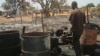 A man looks over what remains of one of the dozens of shops that were gutted by fire in a market in Aweil, South Sudan on Thursday, March 28, 2013. (VOA/Hou Akot Hou)