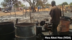 A man looks over what remains of one of the dozens of shops that were gutted by fire in a market in Aweil, South Sudan on Thursday, March 28, 2013. (VOA/Hou Akot Hou)