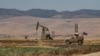 A US armoured vehicle drives past an oil field in the countryside of al-Qahtaniyah town in Syria's northeastern Hasakeh province near the Turkish border, on Aug. 4, 2020.