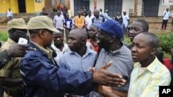 Uganda's main opposition leader Kizza Besigye (3rd L) and his supporters are blocked by policemen during a 'walk-to-work' protest in Kasangati suburb near Uganda's capital Kampala, October 18, 2011.