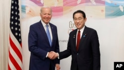 Presiden AS Joe Biden berjabat tangan dengan Perdana Menteri Jepang Fumio Kishida sebelum melangsungkan pertemuan bilateral di Hiroshima, Jepang, pada 18 Mei 2023. (Foto: Kiyoshi Ota/Pool Foto via AP)