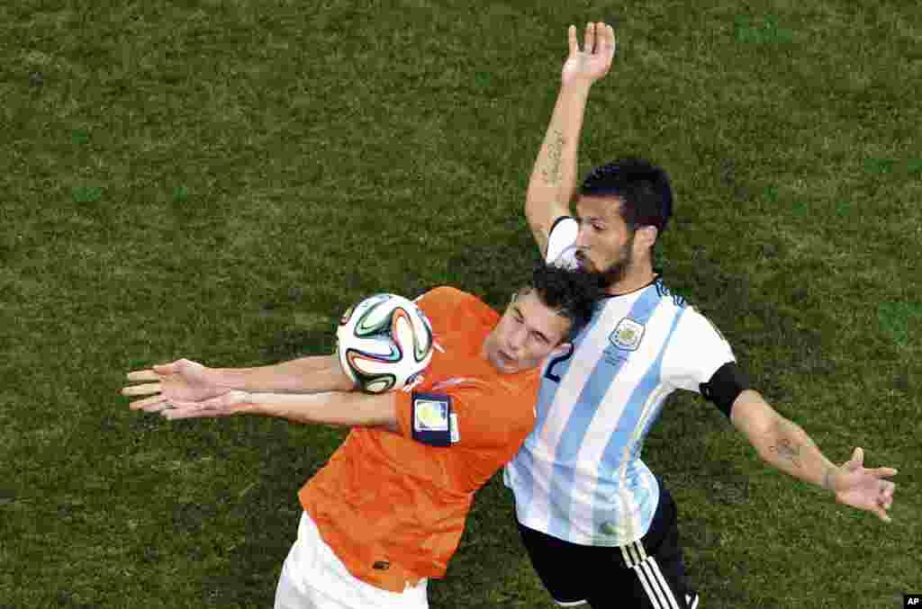 Netherlands' Robin van Persie controls the ball ahead of Argentina's Ezequiel Garay during the World Cup semifinal soccer match at the Itaquerao Stadium in Sao Paulo, Brazil, July 9, 2014.