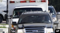 Astronaut Mark Kelly sits in the passenger seat of the ambulance as it carries his wife, U.S. Rep. Gabrielle Giffords, to TIRR Memorial Hermann Rehabilitation Hospital, in Houston, 26 Jan 2011.