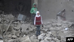 Des enfants marchent dans les ruines à Hamouria, dans la région de la Ghouta, le 22 février 2018.