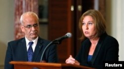 Juru runding utama Palestina Saeb Erekat (kiri) dan Menteri Kehakiman Israel Tzipi Livni dalam jumpa pers di Washington (30/7). 