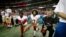 Colin Kaepernick, en el centro, arrodillándose al sonar el himno nacional al comienzo de un encuentro, un gesto que se convirtió en un símbolo y que le costó su carrera como jugador de fútbol americano.