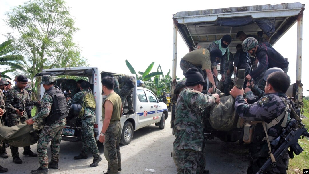 Members of the Philippine National Police Special Action Forces load bodies of police commandos into vehicles in Maguindanao, Philippines, Jan. 26, 2015.