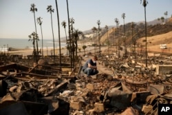 Kevin Marshall memeriksa properti milik ibunya yang hancur akibat kebakaran Palisades Fire di kawasan Pacific Palisades, Los Angeles, 11 Januari 2025. (Foto: AP)