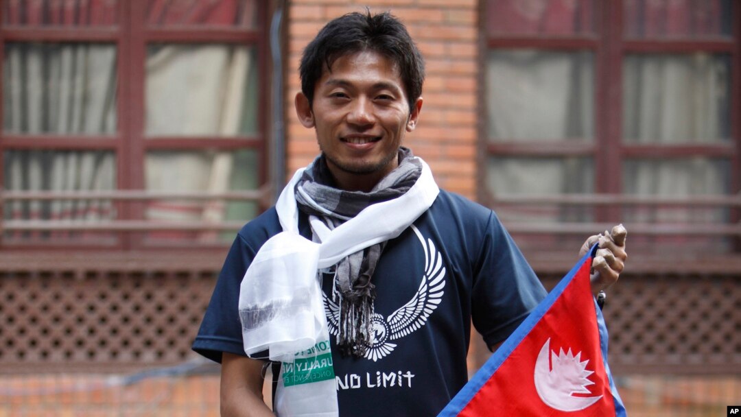 Pendaki Jepang Nobukazu Kuriki berpose dengan bendera Nepal di sela-sela konferensi pers di Kathmandu, Nepal, 23 Agustus 2015.