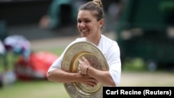 Simona Halep pozira sa trofejem namenjenom pobednici Vimbldona (Foto: Reuters/Carl Recine)