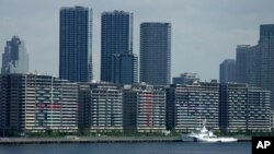 National banners hang from balconies at the athlete's village as Tokyo prepares for the 2020 Summer Olympics, July 17, 2021. 