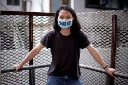 Brother Nut, Chinese performance artist, wearing a face mask poses for a picture in Shanghai.