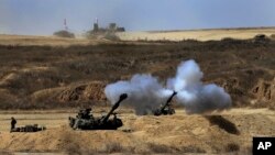 An Israeli tank fires towards Gaza, near the Israel and Gaza border, July 27, 2014.
