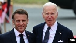 O Presidente francês Emmanuel Macron (à esq.) e o Presidente norte-americano Joe Biden discursam em Omaha, num evento alusivo ao 80.º aniversário do desembarque dos Aliados no “Dia D” da Segunda Guerra Mundial na Normandia, em Saint-Laurent-sur-Mer.