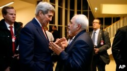 FILE - U.S. Secretary of State John Kerry talks with Iranian Foreign Minister Mohammad Javad Zarif in Vienna, after the International Atomic Energy Agency verified that Iran has met all conditions under the nuclear deal, Jan. 16, 2016.