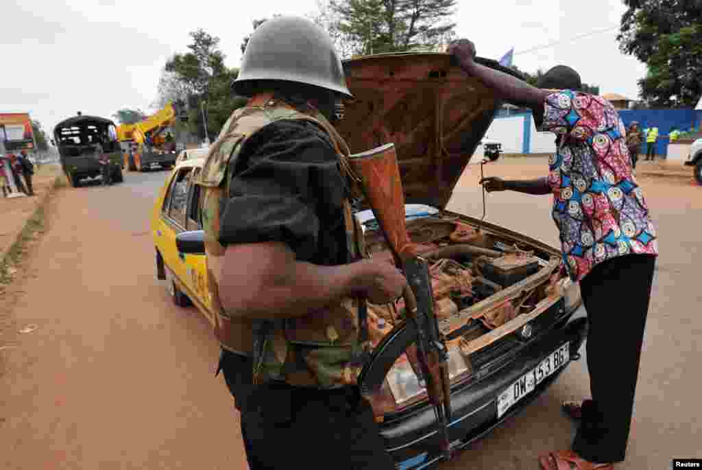 Polisi memeriksa mobil di pos keamanan distrik PK4 di Bangui (27/2).&nbsp;(AFP/Sia Kambou)