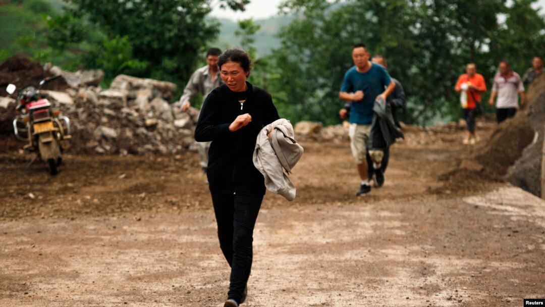 Warga berlari melewati bukit yang beresiko mengalami longsor setelah gempa bumi melanda Ludian di Zhaotong, Yunnan, 3 Agustus 2014. 