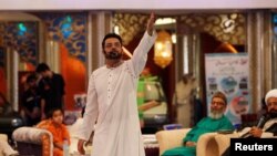 FILE - Aamir Liaquat Hussain gestures during a live show in Karachi, Pakistan, July 26, 2013.