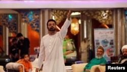 FILE - Aamir Liaquat Hussain gestures during a live show in Karachi, Pakistan, July 26, 2013.