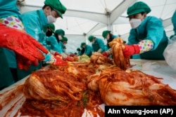 Karyawan Hana Financial Group membuat kimchi untuk disumbangkan kepada tetangga yang membutuhkan di kantor pusat Seoul, Korea Selatan, pada 11 November 2022. (Foto: AP/Ahn Young-joon)