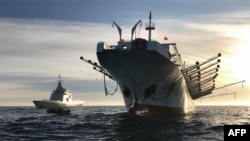 FILE - A handout picture released by Argentina's Navy press office shows the ARA “Bouchard” Ocean Patrol escorting a Chinese flag fishing ship after it was caught illegally operating in Argentina's Exclusive Economic Zone, May 4, 2020.