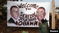 Artist Ouzin puts the finishing touches on a painting honouring the upcoming visit by U.S. President Barack Obama to Dakar, Senegal, June 24, 2013