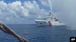 资料照片: 2015年9月23日中国海警队员在南海黄岩岛附近与菲律宾渔民对峙。