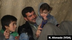 Hoger, left, a 10-year-old Yazidi boy from Sinjar, sits with his orphanage housefather Rami Qaddor and Qaddor’s daughter. Hoger has been living in an orphanage in Atmeh refugee camp, northern Syria.