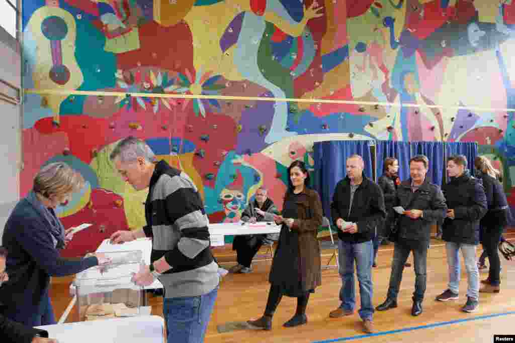 People wait in line to vote during the second round of 2017 French presidential election at a polling station in Bron, May 7, 2017.