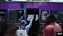 A government health official sprays a chlorine solution on a public transport vehicle as a preventive measure against the COVID-19 coronavirus in Nairobi, March 19, 2020.