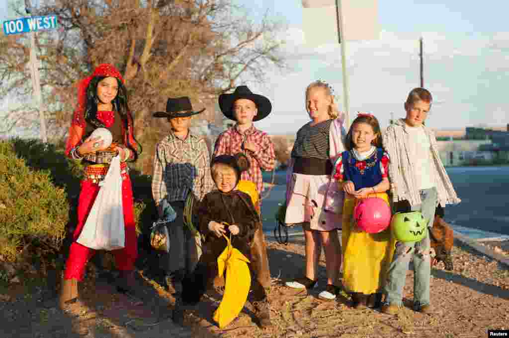 Anak-anak yang sedang melakukan permainan Trick-or-treat berfoto di Blanding, Utah, 31 Oktober 2017.