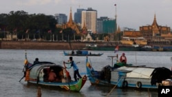 FILE PHOTO- Fishermen row their wooden boats in conjunction with rivers between the Mekong River and Tonle Sap as they catch fish during the fish harvesting season near Phnom Penh, Cambodia, Wednesday, Nov. 28, 2018. (AP Photo/Heng Sinith)