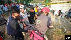 An injured migrant woman is moved by rescue personnel from the site of an accident near Tuxtla Gutierrez, Chiapas state, Mexico, Dec. 9, 2021. migrants rolled over on the highway in southern Mexico. (AP Photo)