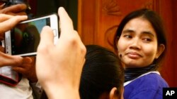 Yorm Bopha, right, a Boeung Kak lake villager, enters a court room for her hearing at the Supreme Court in Phnom Penh, Cambodia, Friday, Nov. 22, 2013.