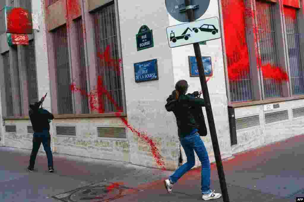 Activists from Action Justice Climate paint the facade of French multinational bank and financial services holding company BNP Paribas at Place de la Bourse in Paris, as they accuse BNP Paribas of financing Israeli state, through the purchase of bonds, and thereby participating in the war in Gaza.