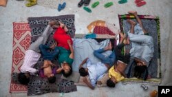 FILE - An Indian family sleeps on the roof of a house to beat the heat in New Delhi, India, May 29, 2015.