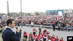 Syria's President Bashar al-Assad addresses his supporters during a surprise appearance at a rally in Umayyad Square in Damascus, January 11, 2012.