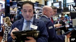 Trader Tommy Kalikas, left, works on the floor of the New York Stock Exchange, Sept. 6, 2016.