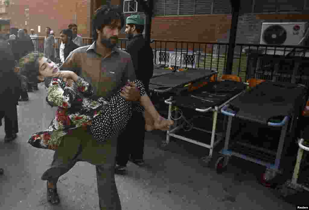 A man carries a girl, who was injured in a bomb blast, as she is brought to the Lady Reading Hospital for treatment in Peshawar, Oct. 7, 2013. 