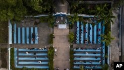 Parishioners attend a mass on the grounds next to earthquake-damaged cathedral in Les Cayes, Haiti, Sunday, Aug. 22, 2021, eight days after a 7.2 magnitude earthquake hit the area.