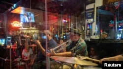 The Catahoula Music Company performs behind protective plexiglass at Maison Bourbon as the coronavirus disease (COVID-19) restrictions are eased in New Orleans, Louisiana, March 13, 2021.