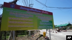 A sign near military checkpoint warns in Thai, English and Chinese of the danger of being trafficked and forced to work in locked scam compounds across the Myanmar border, in Mae Sot, Thailand, Feb. 26, 2025.