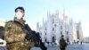 FILE - Military officers wearing face masks stand outside Duomo cathedral, closed by authorities due to a coronavirus outbreak, in Milan, Italy, Feb. 24, 2020.