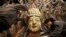 Restoration workers peel off loose gold foil as part of a restoration project for an 800-year-old Thousand-Hand Guanyin Buddhist statue on Mount Baoding in Chongqing municipality, China. The stone-carving statue, which takes up about 88 square metres on the mountain, dates back to the Southern Song Dynasty (1127-1279).