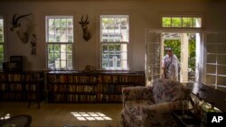 FILE - A visitor peers into the living room at Finca Vigia, home of the late U.S. literary icon Ernest Hemingway in Havana, Cuba, June 15, 2016. 