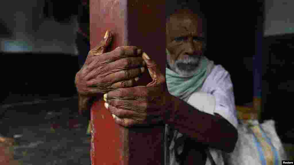 Seorang pria duduk di luar rumahnya, menunggu untuk dievakuasi ke tempat yang lebih aman di desa Donkuru, distrik Srikakulam di negara bagian Andhra Pradesh. (Reuters/Adnan Abidi)