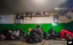 FILE—A Senegalese migrant, center, reads the Qurʾān following morning prayers, while other African migrants rest inside the main prayer area in the basement at Bronx's Masjid Ansaru-Deen mosque, March 15, 2024, in New York.