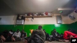 FILE—A Senegalese migrant, center, reads the Qurʾān following morning prayers, while other African migrants rest inside the main prayer area in the basement at Bronx's Masjid Ansaru-Deen mosque, March 15, 2024, in New York.