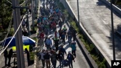 A group of Central American migrants resume their journey north after leaving the temporary shelter at the Jesus Martinez stadium, in Mexico City, Nov. 9, 2018. 